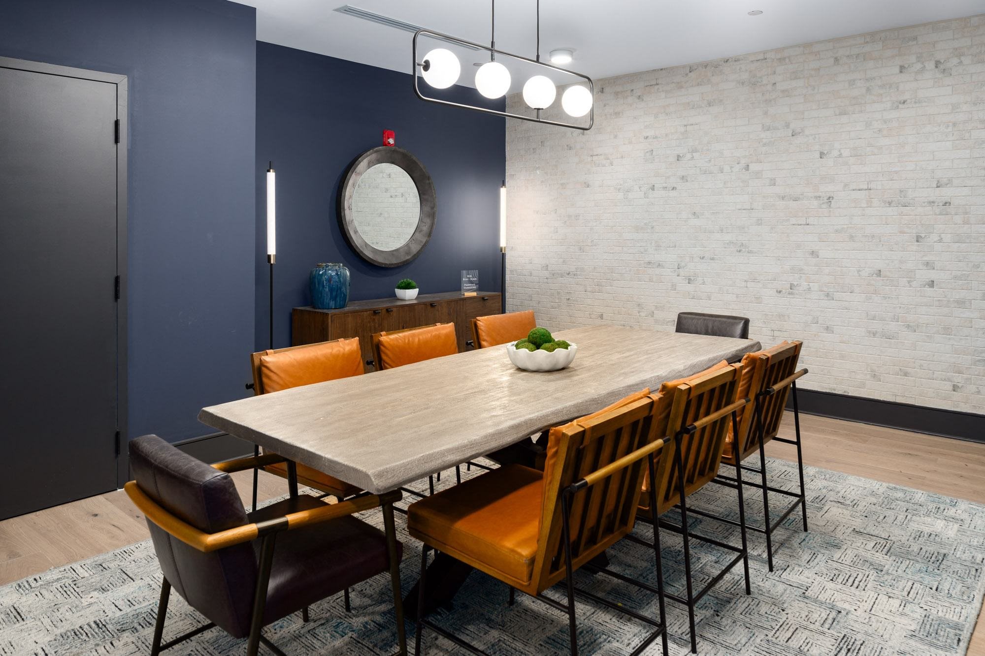a dining room with a wooden table and orange chairs